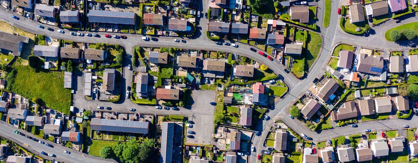 aerial view of a residential area showing houses along streets and gardens