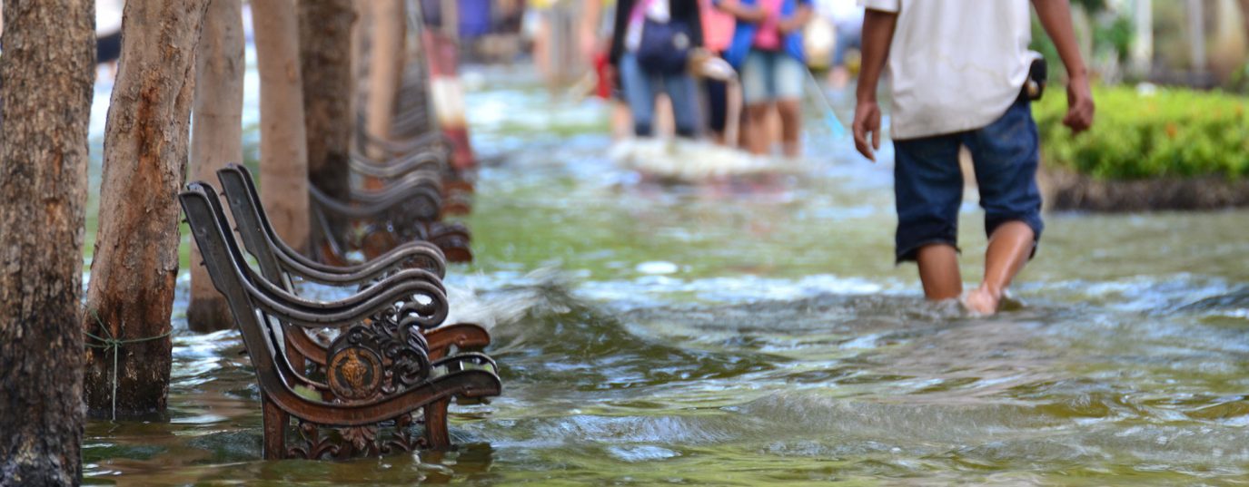 flooded street with people wading through the water
